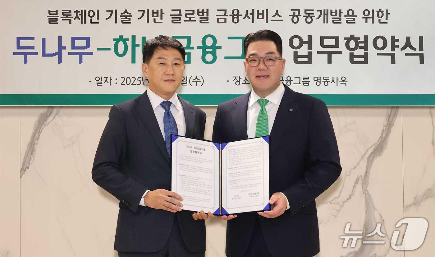 오경석 두나무 대표(사진 왼쪽)와 이은형 하나금융그룹 부회장(사진 오른쪽)이 함께 협약서를 들고 기념촬영을 하고 있다. (하나금융그룹 제공).