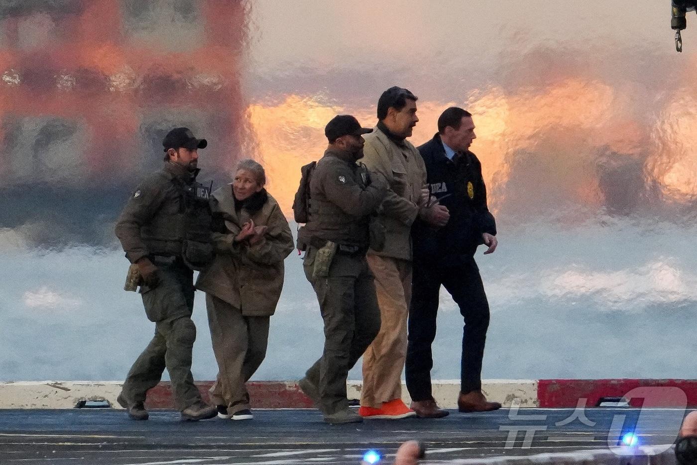 니콜라스 마두로 베네수엘라 대통령과 부인 실리아 플로레스가 5일(현지시간) 미국 뉴욕 맨해튼에 도착한 헬기에서 내려 마약단속국(DEA) 요원들에 의해 연방 법원으로 호송되고 있다. ⓒ 로이터=뉴스1